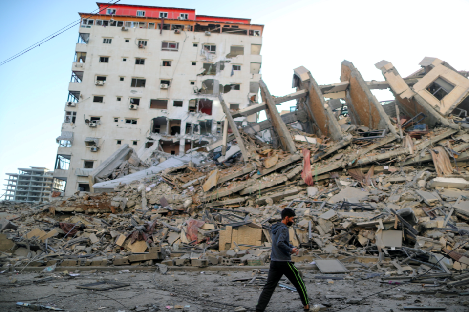 A Palestinian boy walks past the remains of a tower building which was destroyed in Israeli air strikes, in Gaza City. (Reuters/Suhaib Salem)