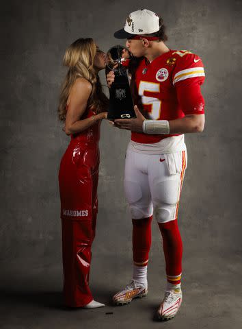 <p>Ryan Kang/Getty</p> Patrick and Brittany Mahomes kiss the Vince Lombardi trophy after the Chiefs' victory