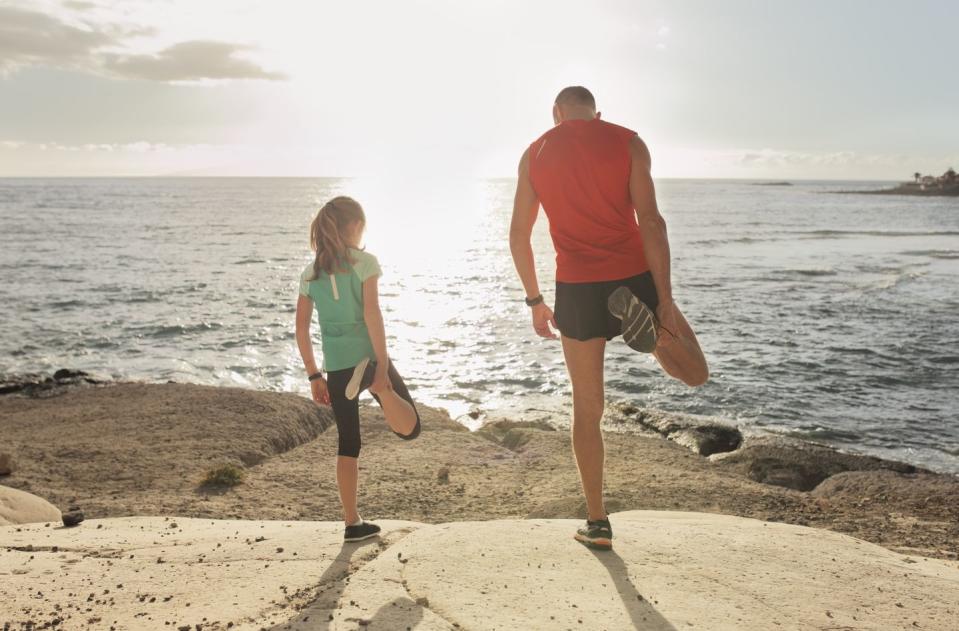 father and daughter stretching during jogging