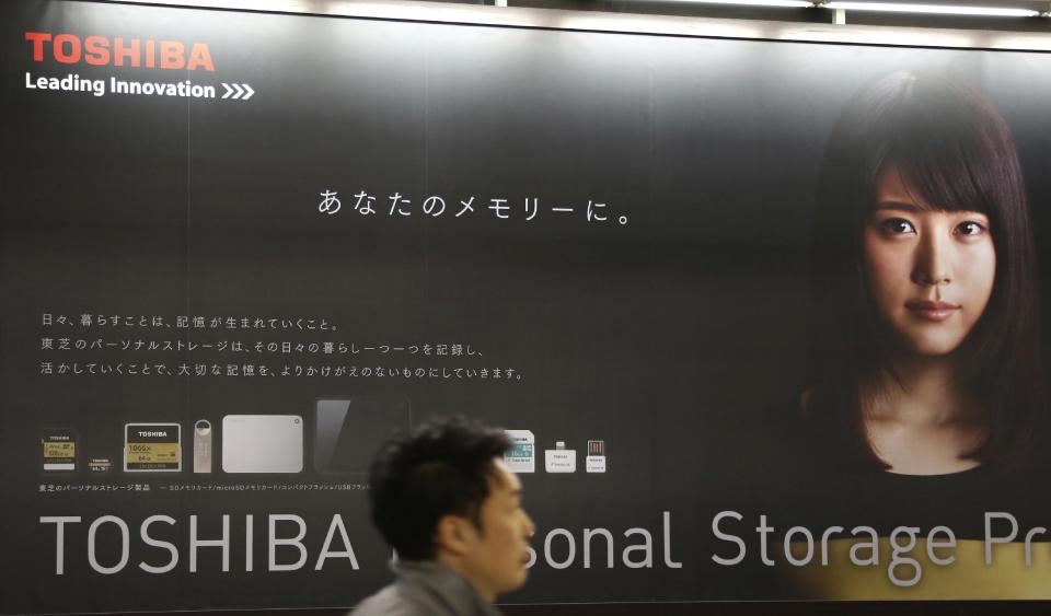 In this Jan. 30, 2017, photo, a man walks past an advertisement of Toshiba Corp.'s products in Tokyo. Japanese electronics and energy giant Toshiba delayed reporting its financial results by a month Tuesday, Feb. 14, 2017, citing problems with its auditing. Toshiba stock tumbled 8 percent in Tokyo trading after its earnings weren't announced as scheduled. The company said the earnings won't be out until March 14. Auditors had questioned Toshiba's reporting on the acquisition of CB&I Stone & Webster by its U.S. nuclear unit Westinghouse, the company said in a statement. (AP Photo/Koji Sasahara)