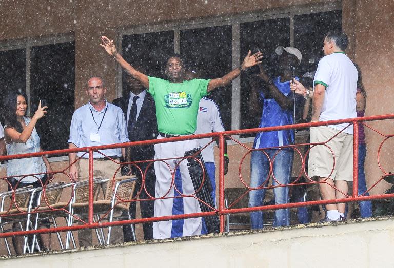 Brazilian football legend Pele (C) waves from a balcony during a Cuba vs New York Cosmos friendly match, in Havana, on June 2, 2015