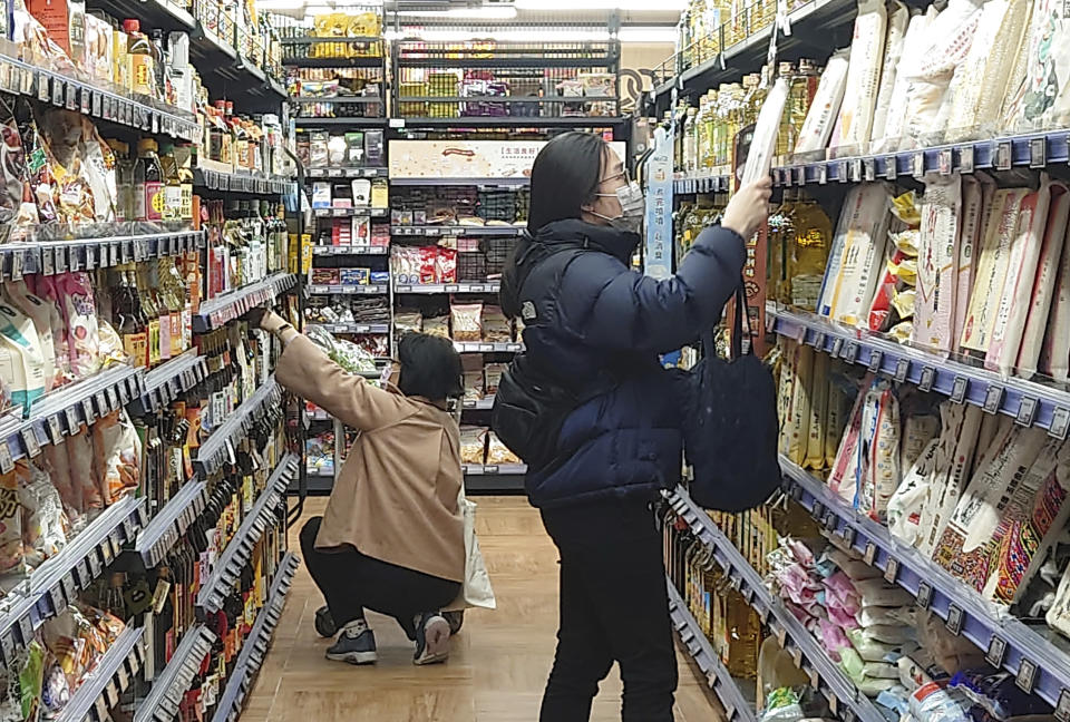 People wear face masks as they shop at a supermarket in Taipei, Taiwan, Monday, Feb. 20, 2023. Three years into the global pandemic, Taiwan said Monday, that people no longer have to wear masks at all times indoors though it is still keeping some restrictions in place. (AP Photo/Chiang Ying-ying)
