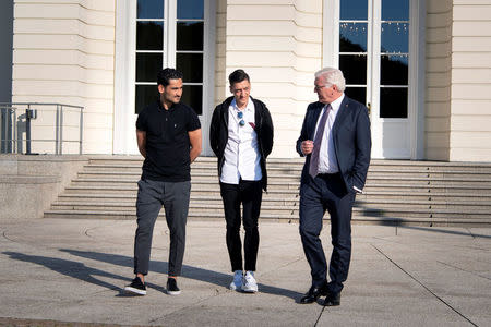 German President Frank-Walter Steinmeier talks to national team players Ilkay Gundogan and Mesut Ozil during a meeting at Bellevue Castle in Berlin, Germany, May 19, 2018. Bundesregierung/Guido Bergmann/Handout via REUTERS