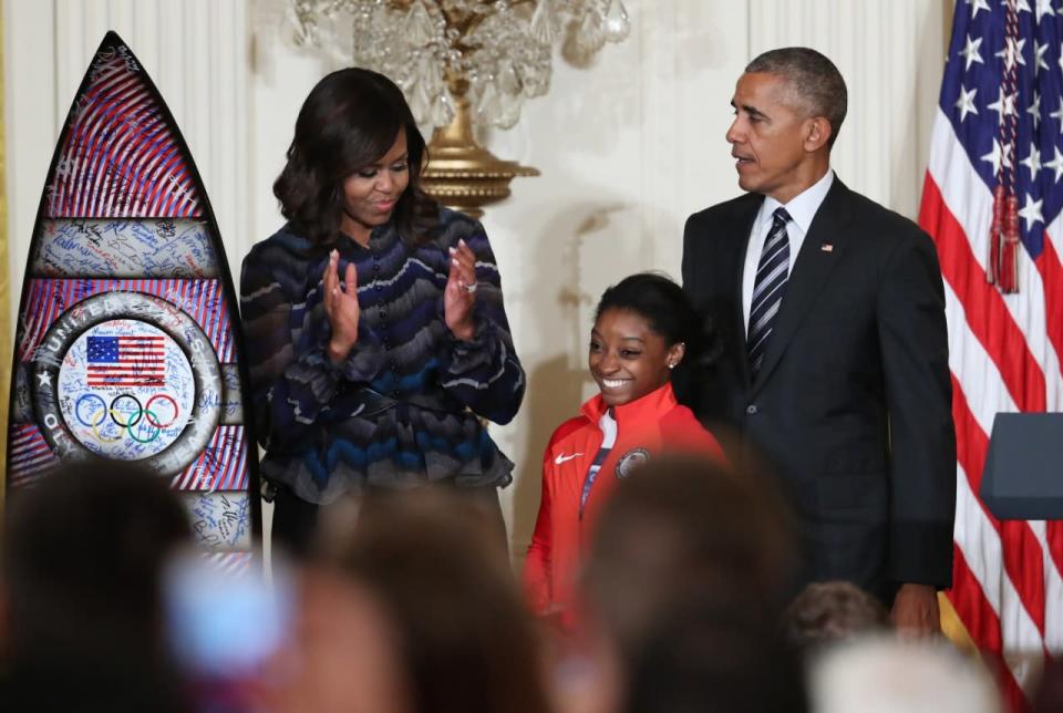 <p>President Barack Obama, with first lady Michelle Obama, is presented a surf board signed by the U.S. 2016 Olympians by Olympic gold medal gymnast Simone Biles during a ceremony honoring the members of the 2016 United States Summer Olympic and Paralympic Teams, Thursday, Sept. 29, 2016, in the East Room of the White House in Washington. (AP Photo/Manuel Balce Ceneta) </p>