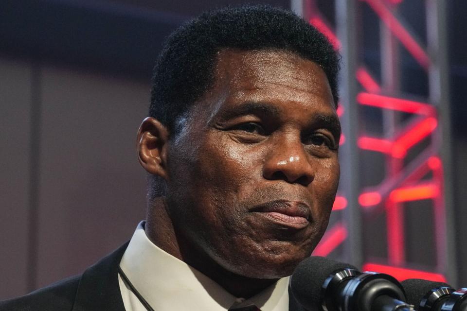 Herschel Walker speaks at a microphone.