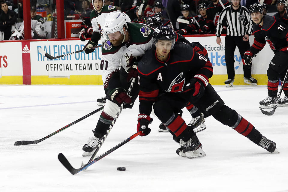 Carolina Hurricanes' Sebastian Aho (20) and Arizona Coyotes' Phil Kessel (81) tussle during the third period of an NHL hockey game in Raleigh, N.C., Sunday, Oct. 31, 2021. (AP Photo/Karl B DeBlaker)