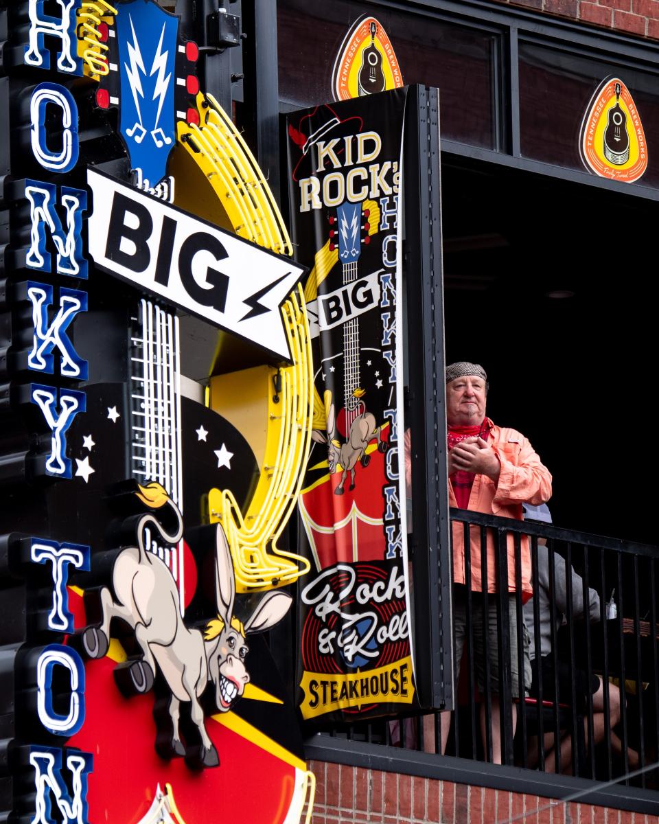 Patrons look out of the window from Kid Rock's Big Ass Honky Tonk Rock N' Roll Steakhouse at Lower Broadway in Nashville on May 25, 2020. Nashville started the second phase of reopening, allowing restaurants and retail stores to open at 75% capacity for the recovery from the COVID 19 pandemic.