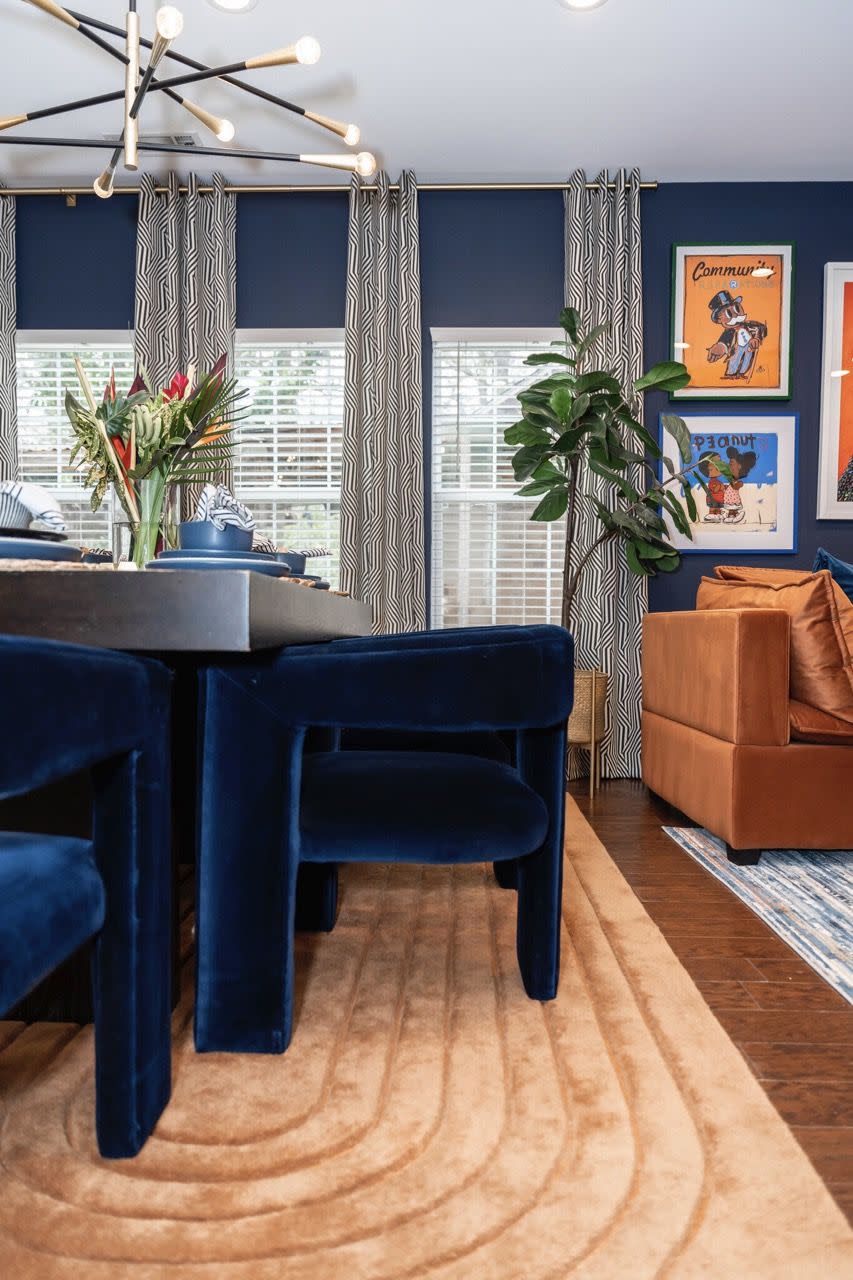 a room with blue chairs and a table with a plant on it