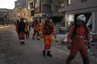 Members of the British rescue team scout the destroyed buildings in Antakya, southern Turkey, Thursday, Feb. 9, 2023. Rescue workers made a final push Thursday to find survivors of the catastrophic earthquake in Turkey and Syria that rendered many communities unrecognizable to their inhabitants. (AP Photo/Khalil Hamra)