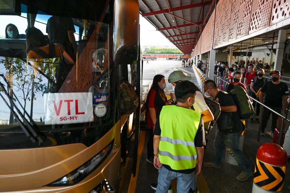 People board a bus in Singapore on November 29, 2021, under the vaccinated travel lane (VTL) for border-crossing passengers to Malaysia&#39;s southern state of Johor. (Photo by Roslan RAHMAN / AFP) (Photo by ROSLAN RAHMAN/AFP via Getty Images)