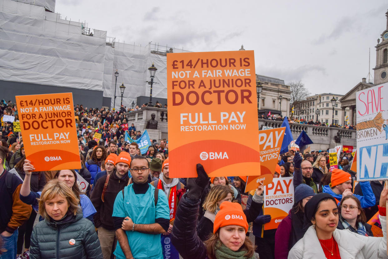 LONDON, UNITED KINGDOM - 2023/03/15: A junior doctor holds a placard calling for fair pay during the demonstration in Trafalgar Square. Thousands of teachers, members of other trade unions and supporters marched to Trafalgar Square on Budget Day demanding fair pay, as various trade unions in multiple sectors staged strikes across the UK. (Photo by Vuk Valcic/SOPA Images/LightRocket via Getty Images)