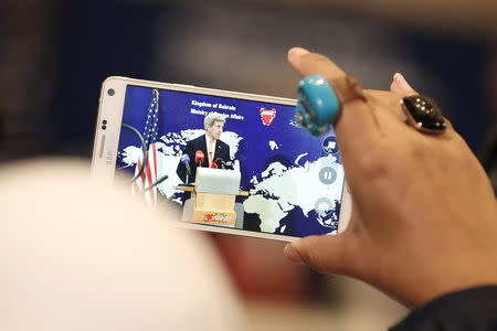 A reporter films U.S. Secretary of State John Kerry speaking ahead of the Gulf Cooperation Council (GCC) Ministerial meeting in Manama, Bahrain April 7, 2016. REUTERS/Hamad I Mohammed.