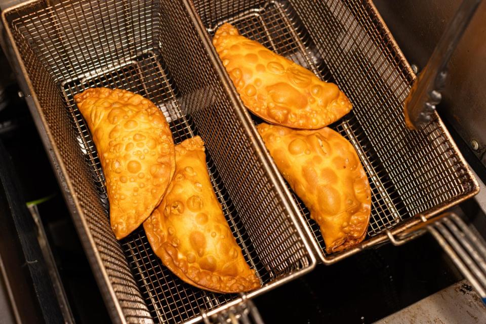 Salami and cheese empanadas and vegetable empanadas in the fryer.