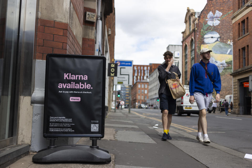 Members of the public pass by a floor advertisement for tech firm Klarna, a European e-commerce company which allows users to buy now, pay later, or pay in installments. (Credit: Daniel Harvey Gonzalez via Getty Images)