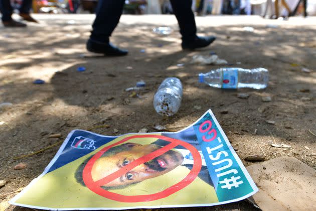 A Sudanese protester walks past a poster bearing a crossed out face of Prime Minister Abdalla Hamdok on the ground, during a rally in front the presidential palace in the capital Khartoum, demanding a return to military rule, on October 21, 2021. - Supporters of Sudan's transitional government took to the streets of the capital today as rival demonstrators kept up a sit-in demanding a return to military rule. The mainstream faction backs the transition to civilian rule, while supporters of the breakaway faction are demanding the military take over. (Photo by AFP) (Photo by -/AFP via Getty Images) (Photo: - via Getty Images)