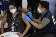 Health Secretary Francisco Duque III, right, injects China's Sinovac vaccine on Filipino doctor Eileen Aniceto during the first batch of vaccination at the Lung Center of the Philippines in Quezon city, Philippines on Monday, March 1, 2021. The Philippines launched a vaccination campaign Monday to contain one of Southeast Asia's worst coronavirus outbreaks but faces supply problems and public resistance, which it hopes to ease by inoculating top officials. (AP Photo/Aaron Favila)