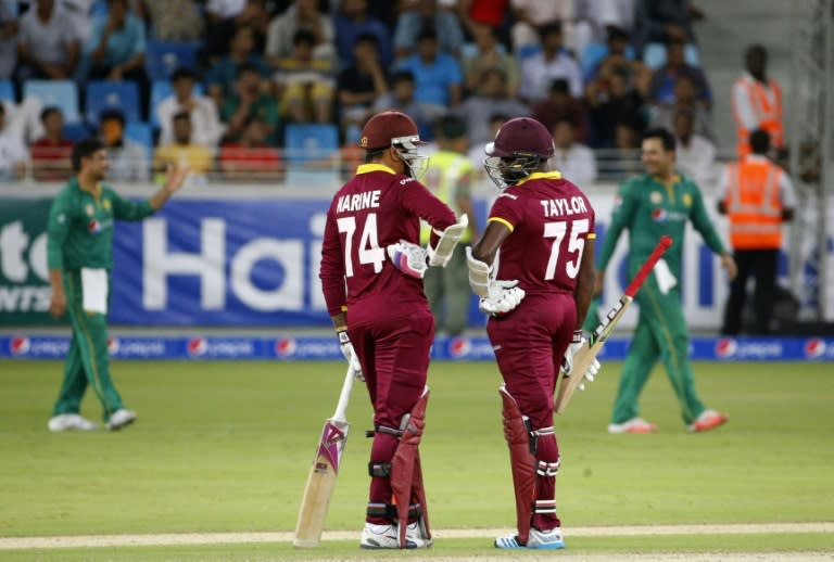 West Indies' batsmen Sunil Narine (L) and Jerome Taylor talk to each other during the T20I match between Pakistan and West Indies at the Dubai International Cricket Stadium on September 24, 2016