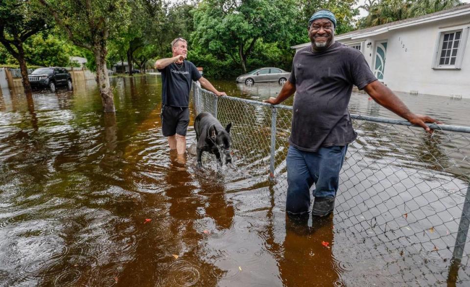 Robert Lee (a la derecha) y su vecino Robert Husted (a la izquierda) examinando las aguas de la inundación que rodean la casa de Lee en NE 123 Street y 11 Court en North Miami, la Florida, el jueves 13 de junio de 2024.