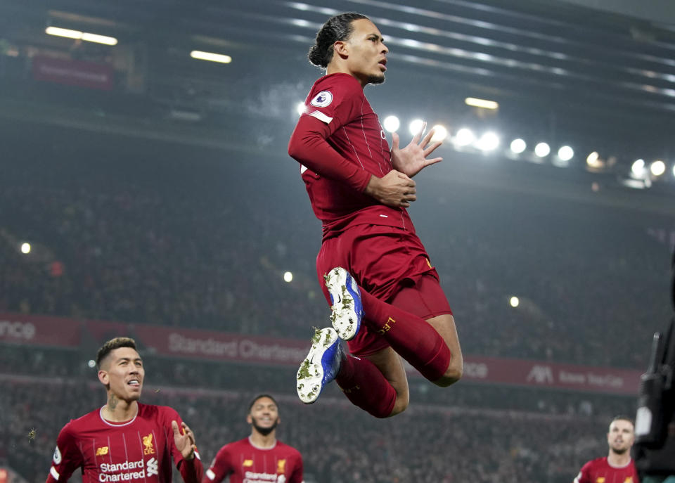 Liverpool's Virgil van Dijk jumps to celebrate scoring his side's first goal during the English Premier League soccer match between Liverpool and Manchester United at Anfield Stadium in Liverpool, Sunday, Jan. 19, 2020.(AP Photo/Jon Super)