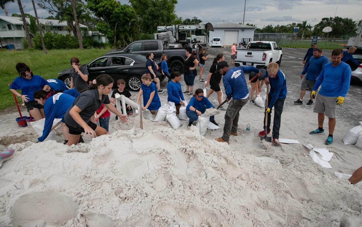 Volunteers collaborate filling sand bags Tuesday, August 29, 2023, in Pine Island in an effort to help local residents prepare for the potential impact of Hurricane Idalia.  