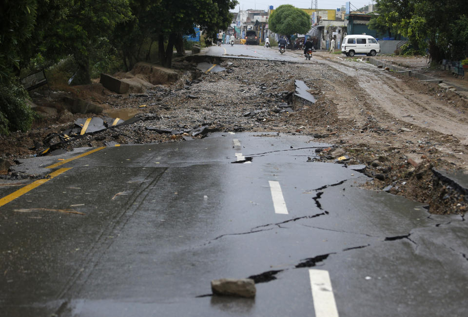 Motorcyclists ride past a damaged portion of a road caused by a powerful earthquake struck in Jatla near Mirpur, in northeast Pakistan, Wednesday, Sept. 25, 2019. A powerful earthquake struck northeast Pakistan Tuesday, badly damaging scores of home and shops and killing some people and injured over 700, officials, said. (AP Photo/Anjum Naveed)
