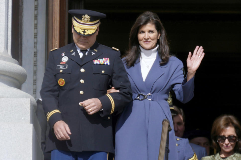 FILE - Former South Carolina Gov. Nikki Haley, right, waves as she and her husband, Michael Haley, left, are introduced at the second inaugural of Gov. Henry McMaster, Jan. 11, 2023, in Columbia, S.C. Nikki Haley’s husband will soon begin a yearlong deployment with the South Carolina Army National Guard to Africa, a mission that will encompass most of the remainder of his wife’s campaign for the 2024 Republican presidential nomination. (AP Photo/Meg Kinnard, File)