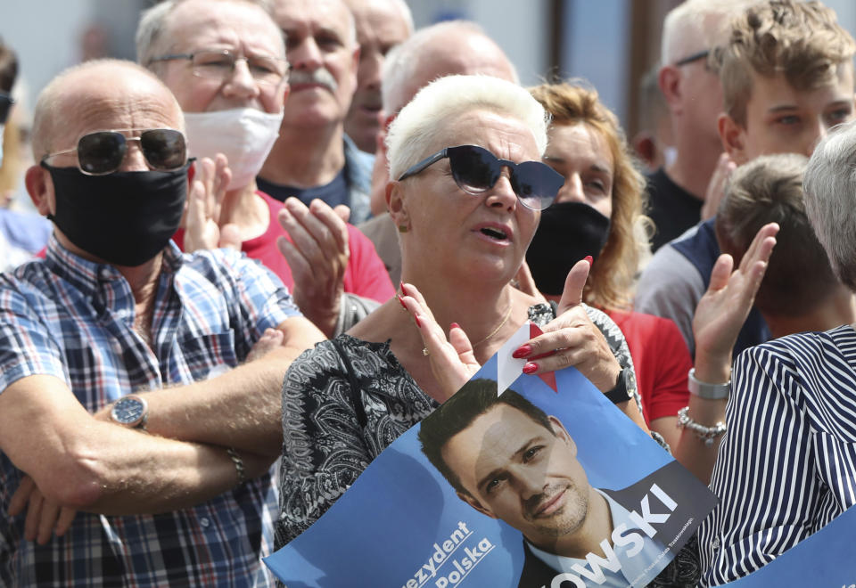 In this Thursday, July 9, 2020 photo people attend a election campaign rally of Rafal Trzaskowski, contender in Poland's tight presidential election runoff on Sunday, July 12, 2020 in Raciaz, Poland. Trzaskowski is running against incumbent conservative president, Andrzej Duda, who has backing from the ruling party. Opinion polls suggest the election may be decided by a small number of votes. (AP Photo/Czarek Sokolowski)