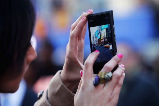 A woman takes a picture of Times Square on her cell phone. The Big Apple may not have California's weather, but tech fans at New York Internet Week say that in every other way the city is on course to become Silicon Valley 2.0