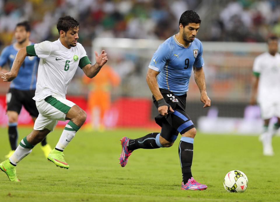 Uruguay's Luis Suarez (R) makes his first appearance since his infamous World Cup biting shame and helps the South Americans to a 1-1 friendly draw against Saudi Arabia in Jeddah, October 10, 2014 (AFP Photo/)