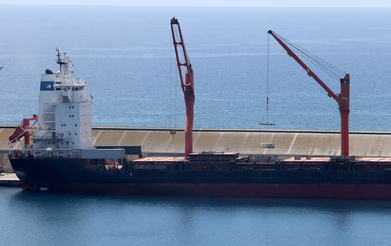 A crane lifts material onto a cargo vessel expected to take aid to Gaza from Cyprus, at the port of Larnaca