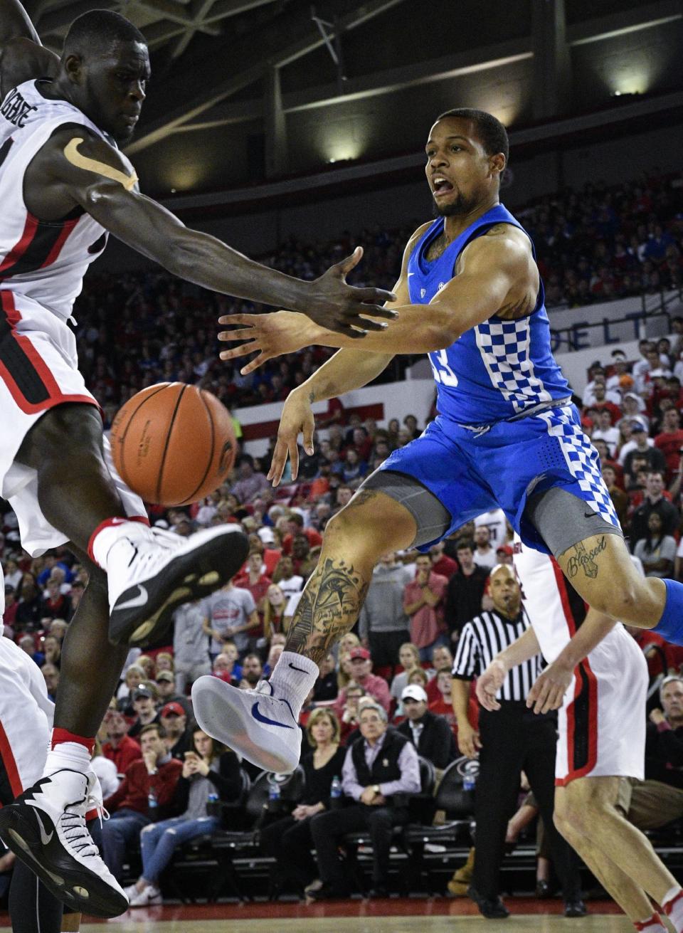 Kentucky guard Isaiah Briscoe, right, passes as Georgia forward Derek Ogbeide defends during the first half of an NCAA basketball game, Saturday, Feb. 18, 2017, in Athens, Ga. (AP Photo/John Amis)