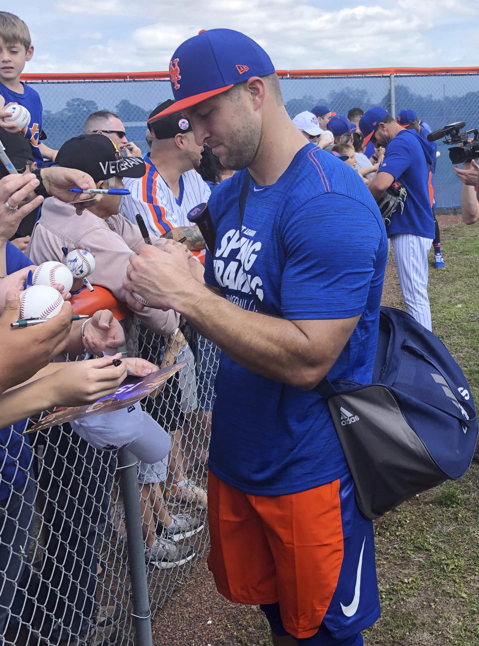 New York Mets' Tim Tebow signs autographs at spring training baseball practice Saturday, Feb. 16, 2019, in Port St. Lucie, Fla. (AP Photo/Mike Fitzpatrick)