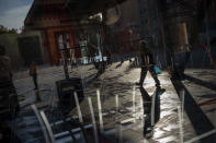 People walk past a restaurant closed due to the sharp resurgence of coronavirus cases, in Barcelona, Spain, Friday, Oct. 23, 2020. Spain has reported 1 million confirmed infections — the highest number in Western Europe — and at least 34,000 deaths from COVID-19, although experts say the number is much higher since many cases were missed because of testing shortages and other problems. (AP Photo/Emilio Morenatti)