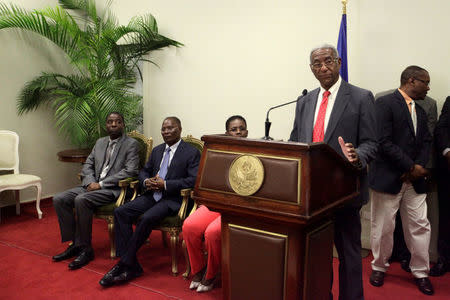 Interim Prime Minister Enex Jean-Charles (L) and Interim President Jocelerme Privert (2nd L) listen Francois Benoit, the president of the commission set up to re-examine the first round election results, speaks at the National Palace in Port-au-Prince, Haiti, May 30, 2016. REUTERS/Andres Martinez Casares