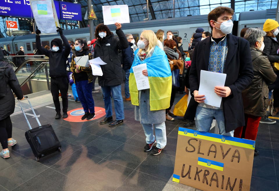 Volunteers wait with information leaflet for people from Ukraine arriving from Poland at the Berlin main train station Hauptbahnhof, after Russia launched a massive military operation against Ukraine, in Berlin, Germany, February 27, 2022. REUTERS/Fabrizio Bensch