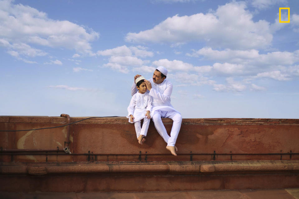 "A beautiful photo of a father and son sitting in white traditional attire with beautiful blue sky on the day of Eid al-Fitr in a mosque in New Delhi, India. The photo shows the beautiful bond which these two generations have been building up in a very simple and lovable manner." ― <a href="http://yourshot.nationalgeographic.com/profile/1378291/" target="_blank">Jobit George</a>&nbsp;(<a href="http://travel.nationalgeographic.com/photographer-of-the-year-2017/gallery/winners-all/12" target="_blank">Honorable mention, People</a>)