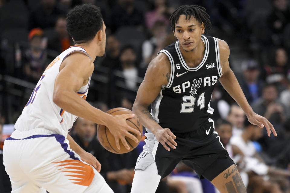 San Antonio Spurs' Devin Vassell (24) guards against Phoenix Suns' Landry Shamet during the second half of an NBA basketball game, Sunday, Dec. 4, 2022, in San Antonio. (AP Photo/Darren Abate)