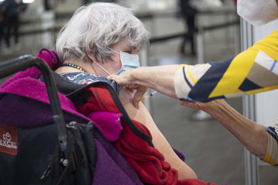 HELMOND, NETHERLANDS - 2021/04/27: A woman receives a dose of the Pfizer, Covid19 vaccine at the XL Covid19 vaccination center in Helmond. 
A mega XL Covid19 Vaccination center opened in Helmond providing more than 5000 jabs per day. The new location, a former factory that has been converted to a Covid19 Vaccination center being operated by GGD and currently providing Pfizer vaccines. (Photo by Nik Oiko/SOPA Images/LightRocket via Getty Images)