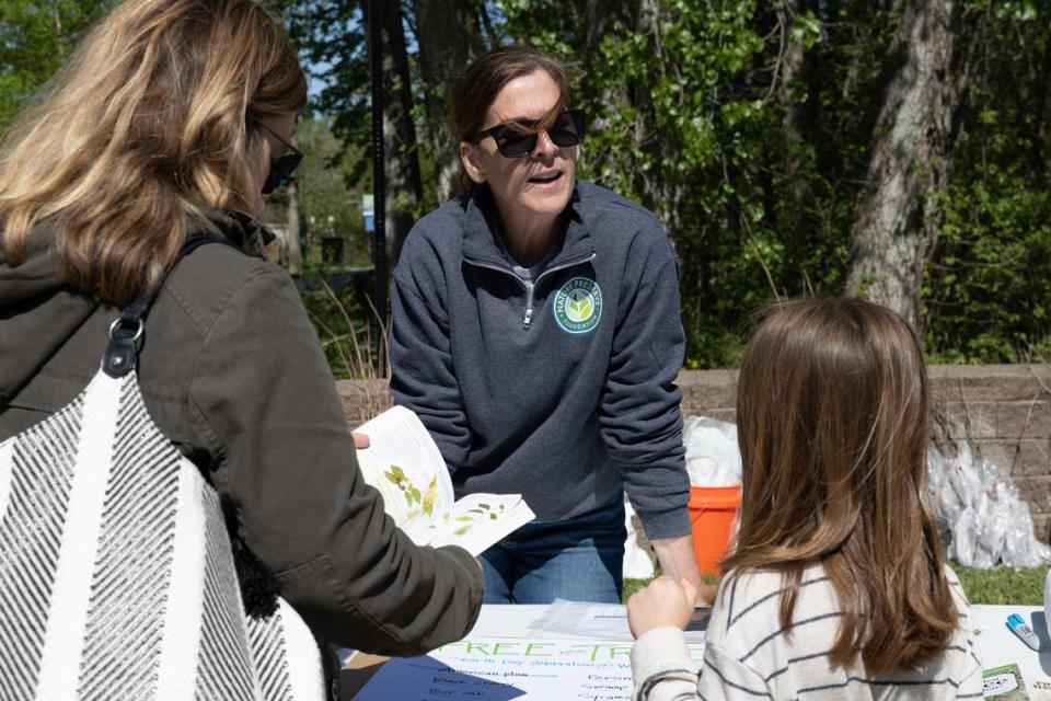 Sheila Voss, a board member of Nature Preserve Foundation, helps distribute free Illinois-native trees at Watershed Nature Center in Edwardsville, Ill. during Earth Day on April 20, 2024. Trees ranged from sycamores and bur oak to fruit baring trees like persimmons.