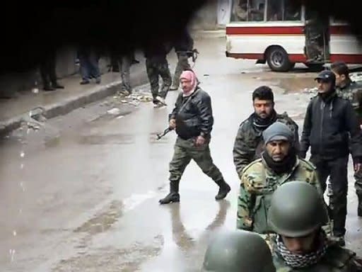 An image grab taken from a video uploaded on YouTube by Syrian opposition shows Syrian security forces walking in the town of Kanaker. AFP is not in a position to independently verify this image