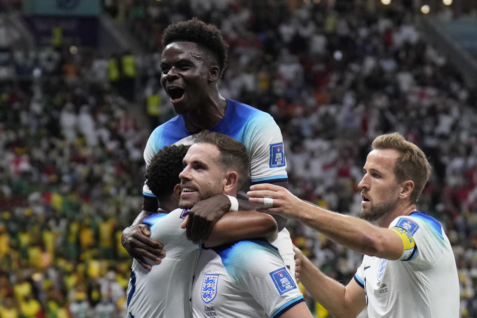 England's Jordan Henderson, center, celebrates with his teammates after scoring his side's first goal during the World Cup round of 16 soccer match between England and Senegal, at the Al Bayt Stadium in Al Khor, Qatar, Sunday, Dec. 4, 2022. (AP Photo/Hassan Ammar)