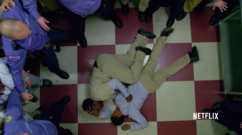 Taystee laying on the floor with Poussey's body surrounded by guards and inmates on "Orange is the New Black"