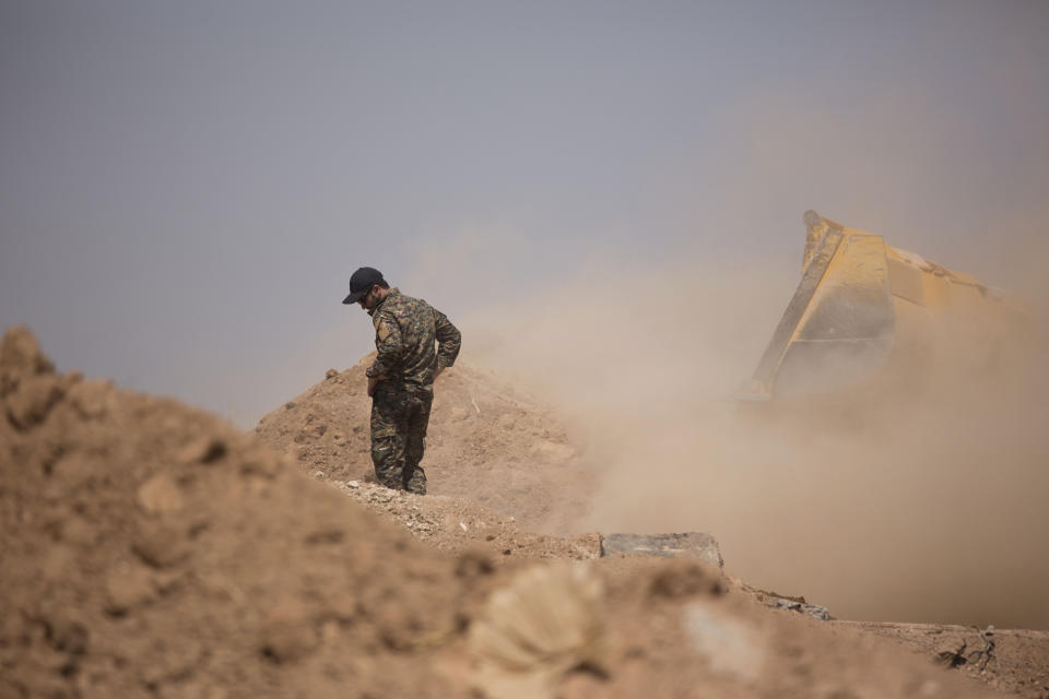 A member of the Tal Abyad Military Council, an affiliate of the U.S.-backed Syrian Democratic Forces, oversees the removal of a fortification in the safe zone between Syria and the Turkish border near Tal Abyad, Syria, Friday, Sept. 6, 2019. Once part of the sprawling territories controlled by the Islamic State group, the villages are under threat of an attack from Turkey which considers their liberators, the U.S-backed Syrian Kurdish-led forces, terrorists.T o forestall violence between its two allies along the border it has helped clear of IS militants, Washington has upped its involvement in this part of Syria.. (AP Photo/Maya Alleruzzo)