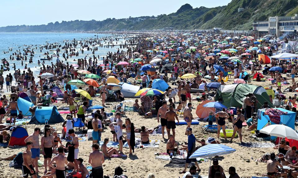 Beachgoers enjoy the sunshine as they sunbathe and play in the sea on Bournemouth beach in Bournemouth, southern England, on June 25, 2020. - Just days after lockdown ended and European travel restrictions were lifted, many were staying home in the cool as a heatwave hit the continent with temperatures touching 40 degrees Celcius. Britain was bracing for a flood of visitors to its beaches with the heatwave expected to last until Friday and temperatures set to climb into the mid-30s in the south and centre of the country. (Photo by Glyn KIRK / AFP) (Photo by GLYN KIRK/AFP via Getty Images)