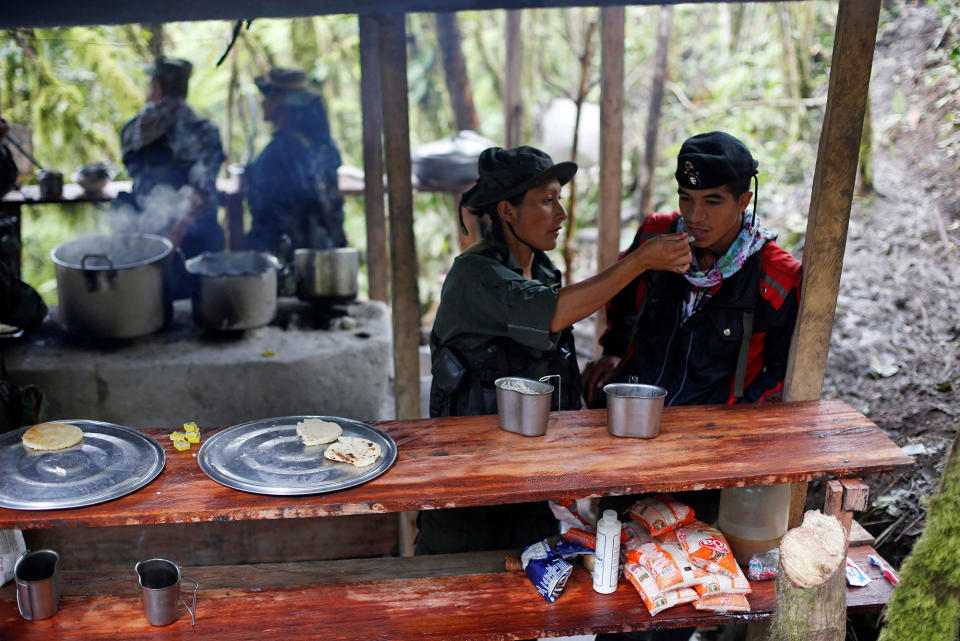 <p>Yuli and Eduar of the 51st Front of the Revolutionary Armed Forces of Colombia (FARC) eat at a camp in Cordillera Oriental, Colombia, August 16, 2016. (John Vizcaino/Reuters) </p>