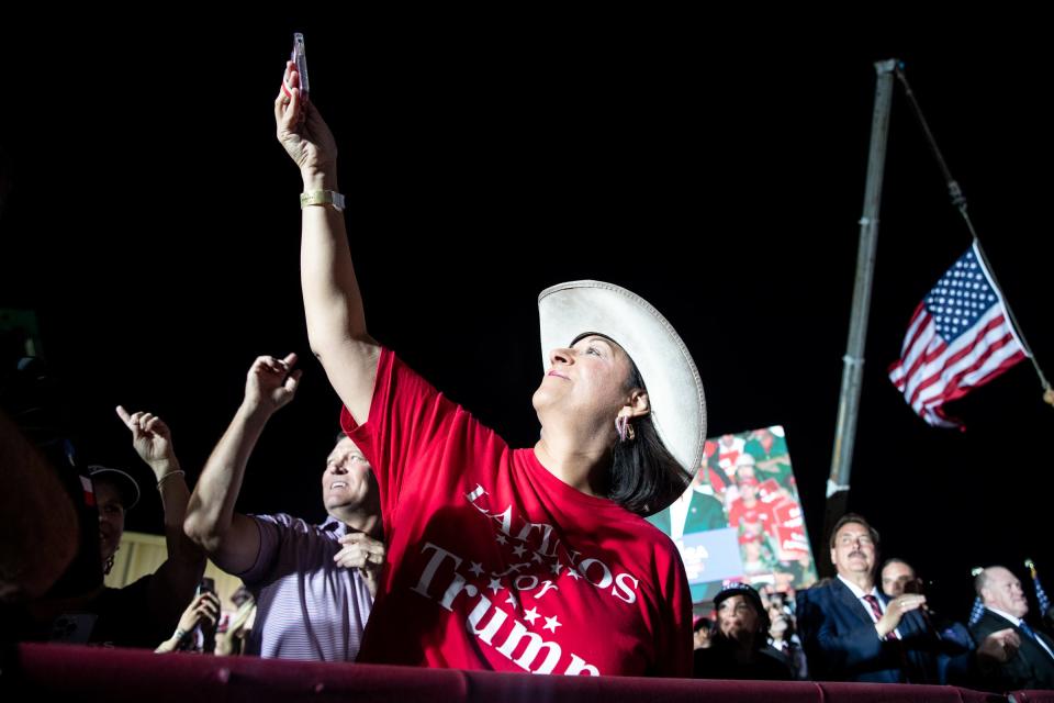 Bianca Garcia, president of the Latinos for Trump Organization, lifts her phone up for footage of former U.S. President Donald Trump at his Texas rally at the Richard M. Borchard Regional Fairgrounds on Saturday, Oct. 22. 2022, in Robstown.