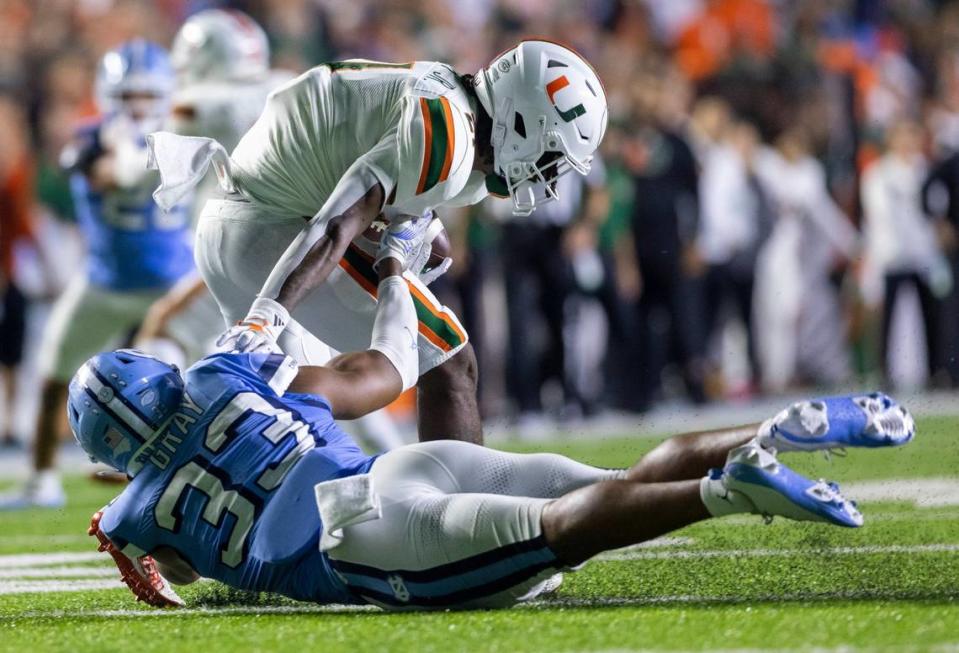 North Carolina’s Cedric Gray (33) stops Miami’s Henry Parrish Jr. (21) for a three-yard loss in the second quarter on Saturday, October 14, 2023 at Kenan Stadium in Chapel Hill, N.C.