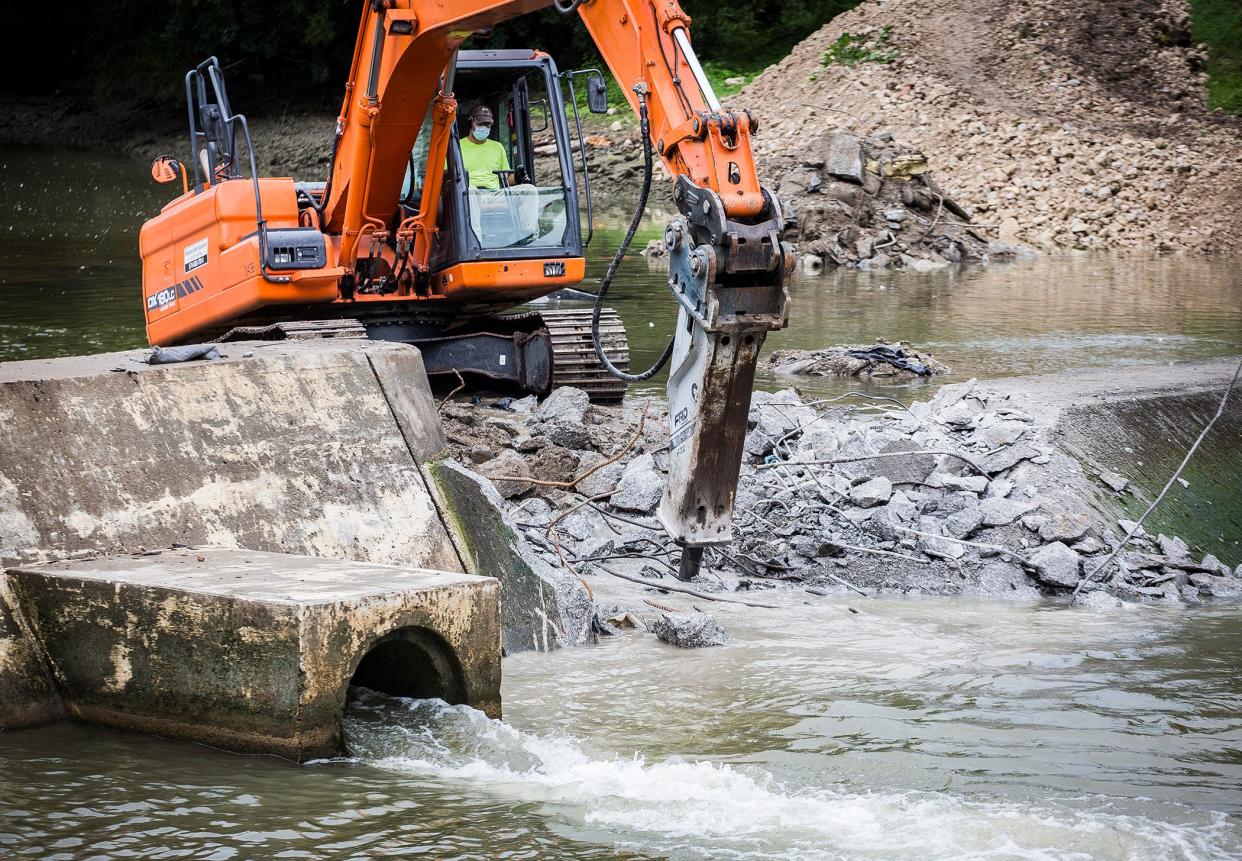 A construction crew breaks apart a dam near McCulloch Park in the White River. The City, with help from the DNR, is removing the dam to help local wildlife. 