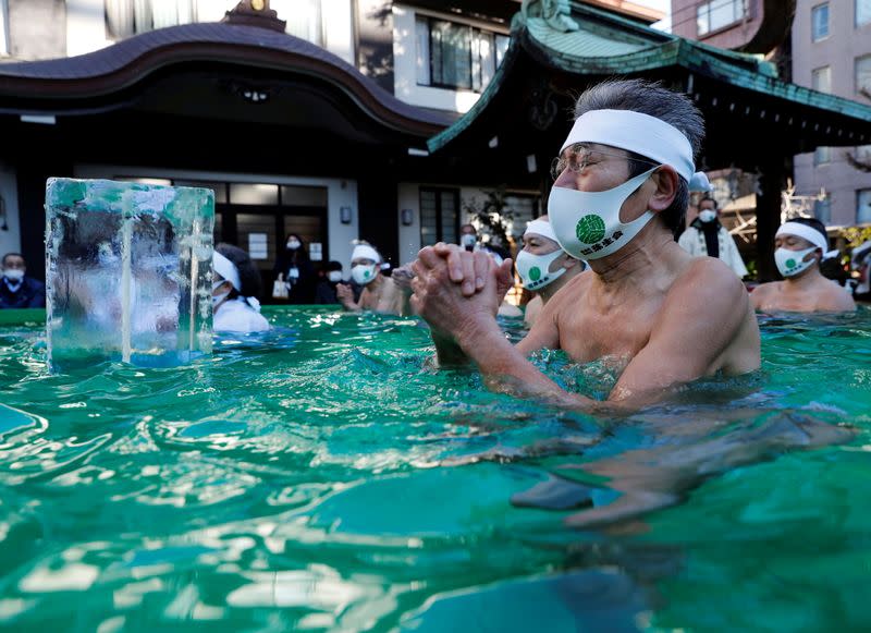 Participants wearing protective face masks amid the coronavirus disease (COVID-19) outbreak, take an ice-cold bath at a ceremony in Tokyo