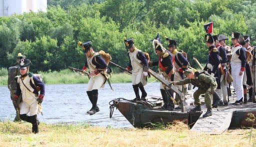 Men dressed as soldiers get out of a modern boat as they take part in a historical reenactment of Napoleon Bonaparte's June 24, 1812 assault on Tsarist Russia, on June 23 on the banks of the river Neman in Kaunas, central Lithuania. The spectacular reenactment drew more than 1,000 participants from France, Russia and across the region